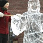 Artist Tjaasa Gusfors poses next to her Jesus Christ ice statue outside the ‘Tomaskyrkan’ church in Vasteras