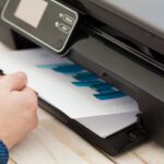 Man’s hand making copies. Working with printer